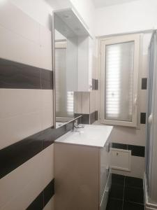 La salle de bains blanche est pourvue d'un lavabo et d'un miroir. dans l'établissement Casa Casello alloggio vacanze, à Trappeto