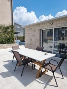 a white table and chairs on a patio at Villa with Pool & Garden apartment 1 Ognjen in Tivat