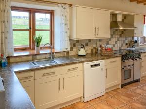 a kitchen with white cabinets and a sink at The Hop Pocket in Bromyard