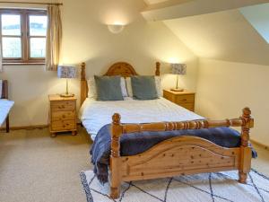 a bedroom with a wooden bed and two night stands at The Hop Pocket in Bromyard