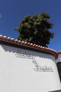 un panneau sur le côté d'un bâtiment avec un arbre en arrière-plan dans l'établissement SOLAR DOS FRADES, à Ferreira do Alentejo