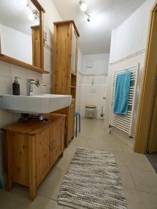 uma casa de banho com um lavatório e um WC em Ferienwohnung Grüner Flamingo em Freisen