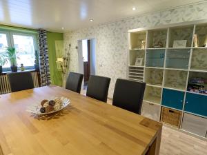 - une salle à manger avec une table et des chaises en bois dans l'établissement Ferienwohnung Grüner Flamingo, à Freisen