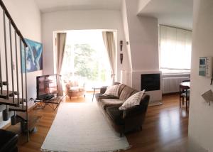 a living room with a couch and a television at Residenza Alice 2 - Toscana mare e monti in Camaiore