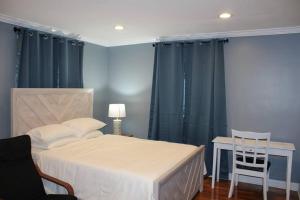 een slaapkamer met een bed, een tafel en een stoel bij Beautiful place minutes away to New York City . in Teaneck