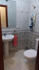 een badkamer met een wastafel, een toilet en een spiegel bij Apartamento Andalucía in Córdoba