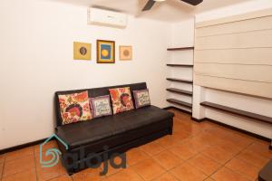 a living room with a black leather couch at Apartamento amplio en zona ideal a 5min de WALLMART in Cancún