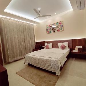 a bedroom with a bed and a ceiling fan at Hotel Luxuria in Ludhiana