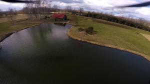 an aerial view of a pond with a barn at Home of Koknese in Koknese