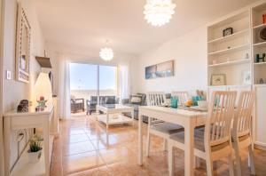 a dining room and living room with a table and chairs at Roque del Conde Seaview in Adeje