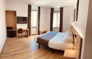 Habitación de hotel con cama y escritorio en Hostal Sol Square Madrid, en Madrid