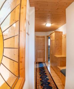 a room with wooden walls and a hallway with a rug at Ruggenthalerhof in Matrei in Osttirol
