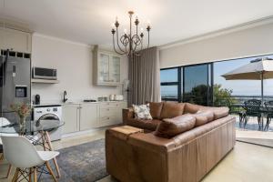 un soggiorno con divano marrone e una cucina di Boskloof Eco House I a Città del Capo