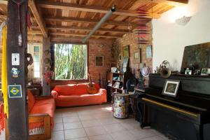 un salon avec un canapé et un piano dans l'établissement Casa em meio a natureza - Ideal para casal, à Rio de Janeiro