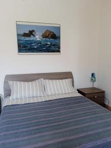 a bedroom with a bed with a blue and white striped bedspread at Piazza Ginnasio Affittacamere in Alghero