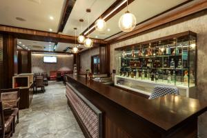 a bar in a restaurant with a counter and chairs at Blisss Hotel, Kolhapur in Kolhapur