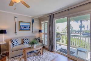 a living room with a couch and a balcony at Sea Cabin 131-B in Isle of Palms