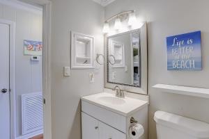 a white bathroom with a sink and a mirror at Sea Cabin 131-B in Isle of Palms