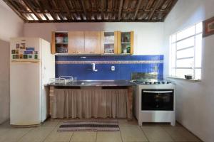 a kitchen with a sink and a refrigerator at Casa em meio a natureza - Ideal para casal in Rio de Janeiro