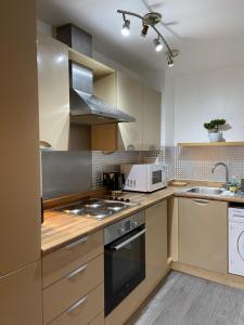 a kitchen with a stove top oven next to a sink at Relocators - Parking - Central in Birmingham
