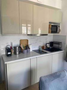 a kitchen with white cabinets and a counter top at Studio refait à neuf en hypercentre avec balcon in Aix-les-Bains