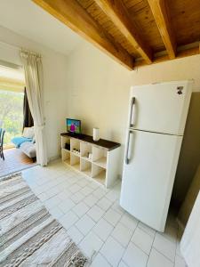 a kitchen with a white refrigerator and a table at Bel appartement avec mezzanine, vue mer et piscine in Cogolin