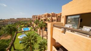 a balcony of a building with palm trees and a resort at Coto Real Kea 431 in Manilva
