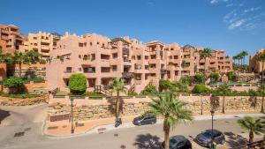 a large building with cars parked in a parking lot at Coto Real Kea 431 in Manilva