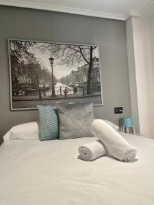 a bedroom with a picture on the wall above a bed at Apartamento Jardín de San Feliz / Fontán in Oviedo