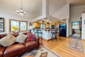 a living room with a brown couch and a kitchen at Elk Trail Retreat in Winter Park