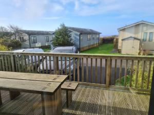 a wooden deck with a wooden bench on a balcony at 3 Bedroom Lodge with Sea Views -Salcombe Retreat in Soar