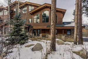 a wooden house in the snow with trees at Elk Trail Retreat in Winter Park