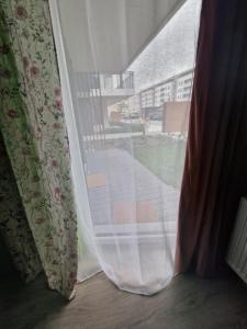 ein Fenster mit einem Vorhang und Blick auf eine Straße in der Unterkunft Oasis in Danzig