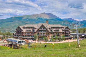 a large building with a playground in front of a mountain at Crystal Peak Lodge By Vail Resorts in Breckenridge