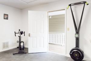 una habitación con gimnasio con cinta de correr y puerta abierta en Baneberry Inn 6, en White Pine