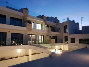 um grande edifício com muitas janelas à noite em Apartamento Sukha Vistas al Mar em Gran Alacant