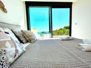 a bedroom with a large bed with a large window at Apartamento Sukha Vistas al Mar in Gran Alacant