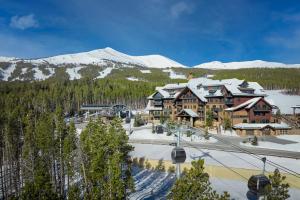 un lodge de esquí con montañas cubiertas de nieve en el fondo en Crystal Peak Lodge By Vail Resorts, en Breckenridge