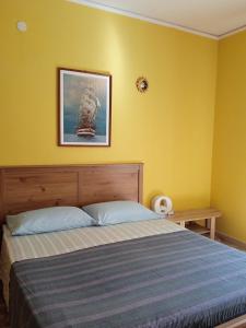 a bedroom with a bed and a yellow wall at Piazza Ginnasio Affittacamere in Alghero