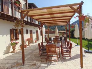 un patio con mesa y sillas bajo una pérgola de madera en Charalambos Holiday Cottage, en Kalavasos