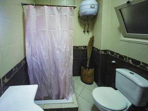 uma casa de banho com um WC e uma cortina de duche rosa. em Flowered private room no Cairo