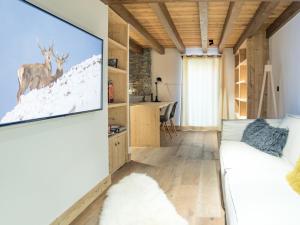 a living room with a tv hanging on the wall at Chalet de Luxe à Saint Martin de Belleville : Spa, Sauna, Proche Pistes et Commerces - FR-1-452-199 in Saint-Martin-de-Belleville