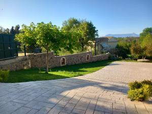 un muro di pietra accanto a un vialetto di Heraklia's house a Perama