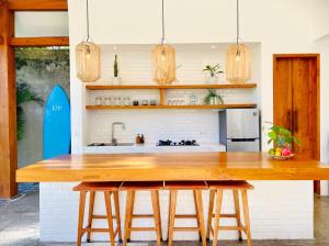a kitchen with a wooden table and a sink at SUNDAY Villa with private pool, near centre and beach in Kuta Lombok