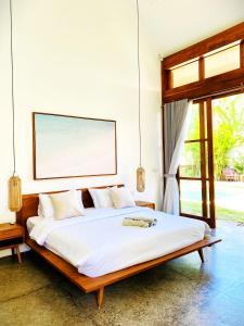 a bedroom with a large bed with white sheets at SUNDAY Villa with private pool, near centre and beach in Kuta Lombok