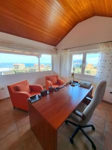 Una habitación con una gran mesa de madera con sillas y ventanas. en Villa Edem, en Ayía Kiriakí