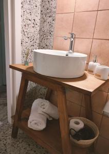 a bathroom sink on a wooden table with towels at Home in nature in Michalítsion