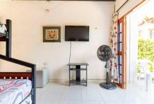 a bedroom with a fan and a tv on the wall at Casa Tara in Taganga