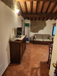 een woonkamer met een bureau, een televisie en een bank bij Casa Fiore in Passignano sul Trasimeno
