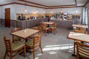 a restaurant with tables and chairs and a counter at Country Inn & Suites by Radisson, Charleston South, WV in Charleston